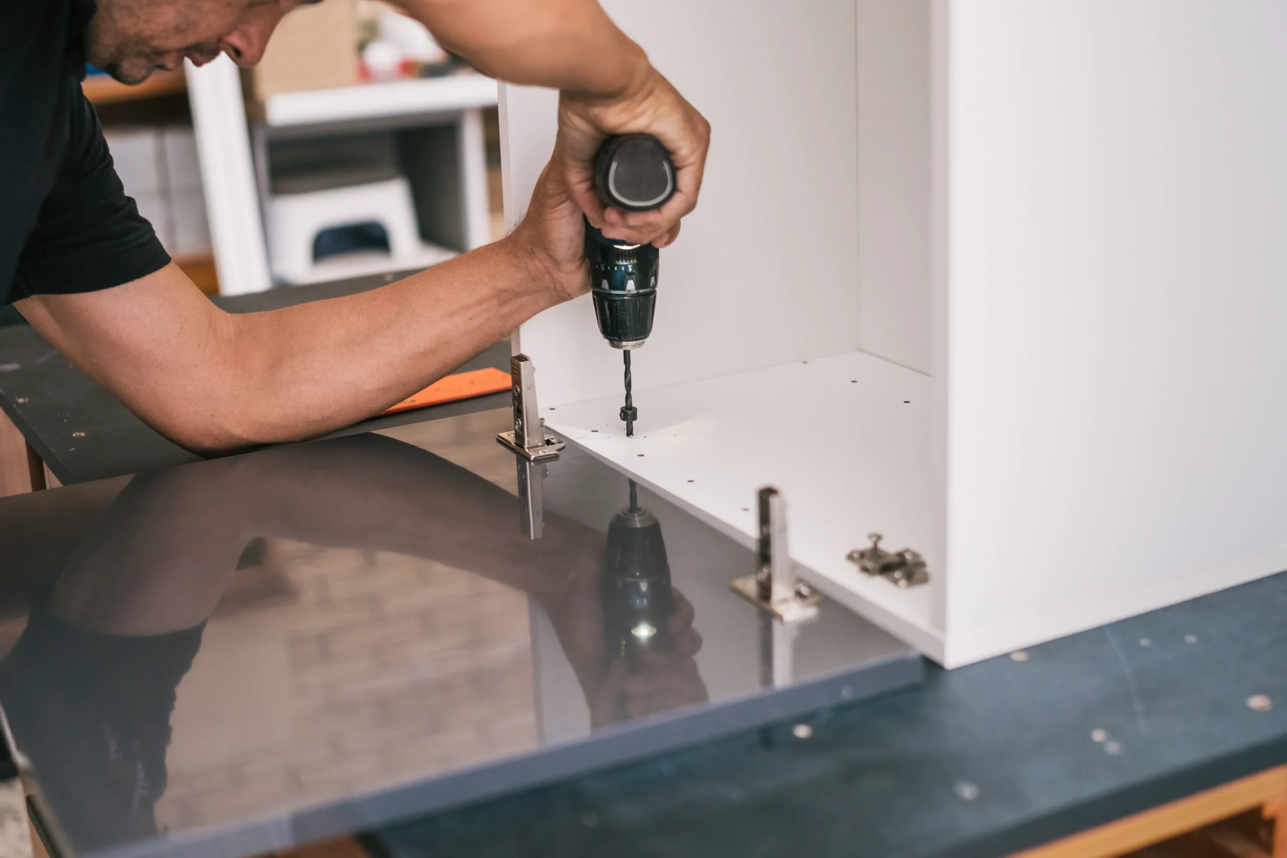 adult-man-drilling-a-wooden-surface-of-a-furniture-2026-01-05-05-47-29-utc